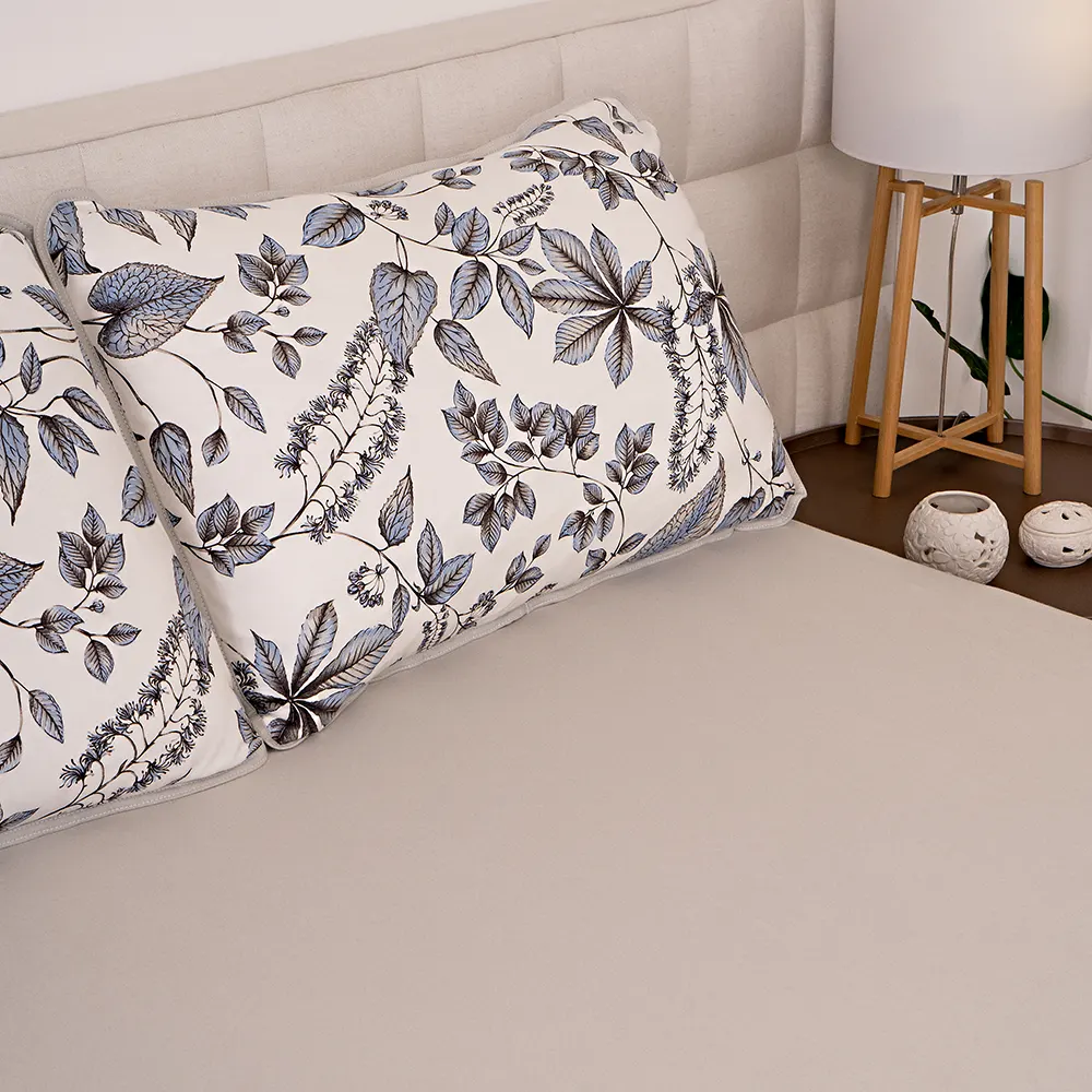 Imagem de travesseiro com estampa de floral sobre uma cama com lençol bege